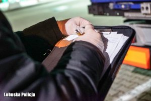 policjant wypełniający dokumentację przy biurku