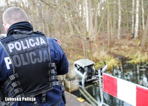 policjant stojący przy jeziorze
